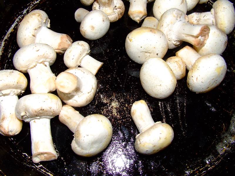les champignons de paris sont mis à dorer dans une poêle avec un peu d'huile